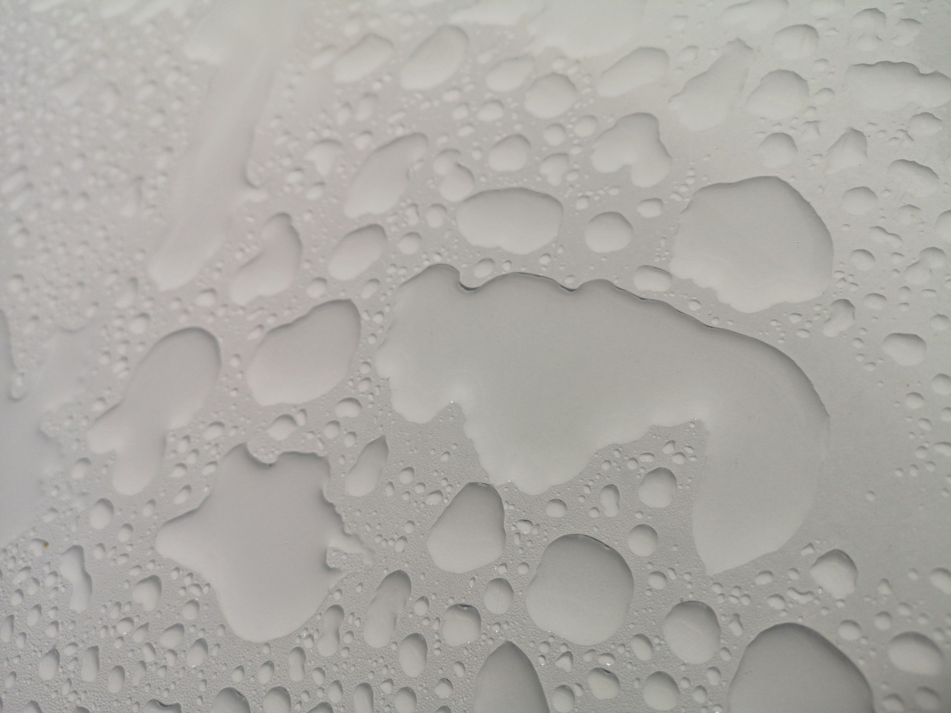 a close up of water drops on a white surface